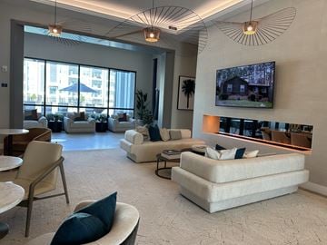 Sarasota apartment for rent - A spacious living room with a large couch and a television mounted on the wall.