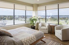 Muskegon apartment for rent - A bedroom with a large bed and a view of the city.