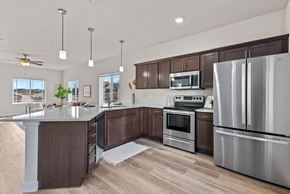 Deforest townhouse for rent - a kitchen with stainless steel appliances and wooden cabinets at The Residences Apartments at Bear Tree, DeForest, 53532