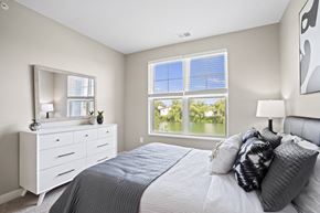 Oconomowoc apartment for rent - a bedroom with a large window and a bed with pillows