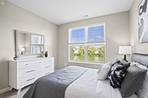 Oconomowoc apartment for rent - a bedroom with a large window and a bed with pillows