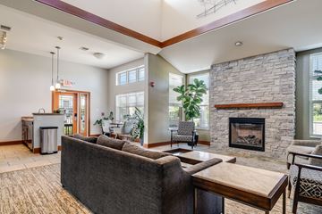 Oconomowoc apartment for rent - A living room with a grey couch and a stone fireplace.