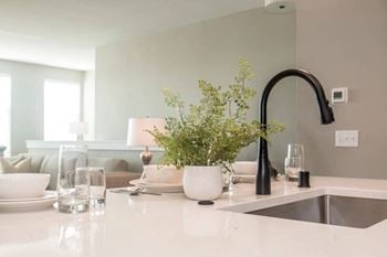 A kitchen counter with a sink and a vase with flowers