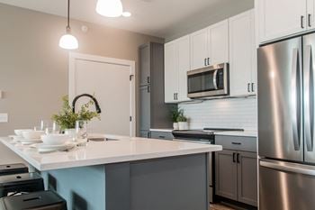 A kitchen with stainless steel appliances and a white counter top