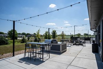 A patio with tables and chairs and a grill