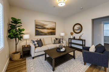 Rohnert Park apartment for rent - A living room with a large painting on the wall and a plant in a basket.