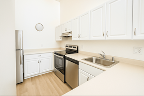 Novato apartment for rent - A kitchen with white cabinets and a black dishwasher.at Hamilton Woods, Novato California