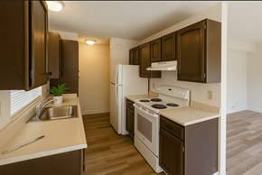 Novato apartment for rent - A kitchen with brown cabinets and white appliances.at Walnut Grove, Novato, CA