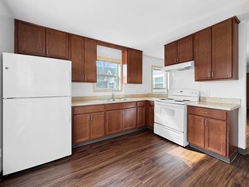 Minneapolis apartment for rent - A kitchen with wooden cabinets and a white fridge.