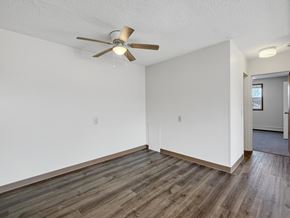 Minneapolis apartment for rent - A room with a ceiling fan and wooden flooring.