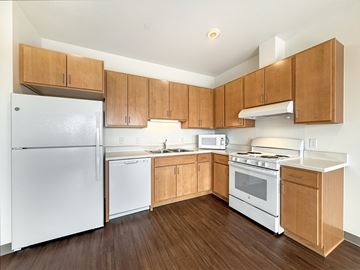 St. Paul apartment for rent - A kitchen with wooden cabinets and white appliances.
