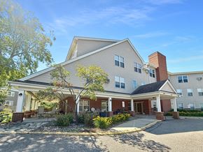 Minnetonka apartment for rent - A two-story building with a covered porch and a brick chimney.