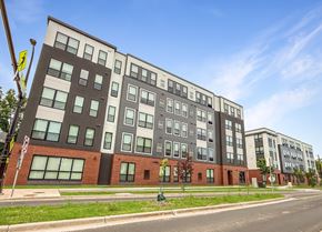 Minneapolis apartment for rent - A modern multi-story building with a mix of dark and light-colored panels.