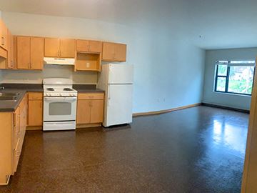 Minneapolis apartment for rent - A kitchen with brown cabinets and a white stove top oven.