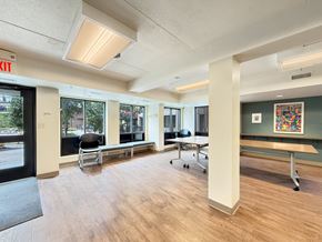 Saint Paul apartment for rent - A room with a wooden floor, a white column, and a black chair.