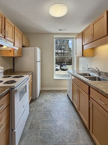 St. Paul apartment for rent - A kitchen with a white stove top oven and white refrigerator.
