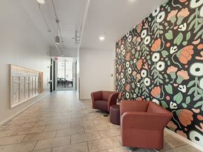 Minneapolis apartment for rent - A hallway with a wallpapered wall and two red chairs.