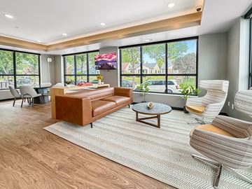 Minneapolis apartment for rent - A living room with a brown leather couch and a grey chair.