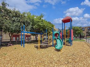 St. Paul apartment for rent - A playground with a red and blue slide and a green slide.