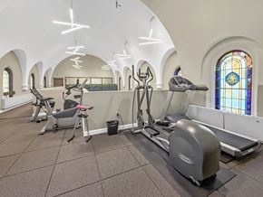 Minneapolis apartment for rent - A gym with exercise equipment and stained glass windows.