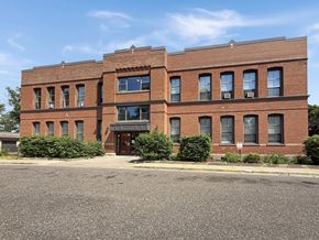 St. Paul apartment for rent - A red brick building with a black awning and a parking lot in front.
