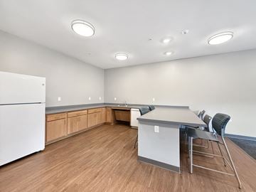 Eden Prairie apartment for rent - A kitchen with a white refrigerator and a table with chairs.