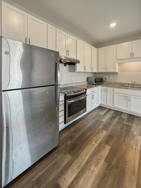 Minneapolis apartment for rent - A kitchen with a stainless steel refrigerator and wooden floors.