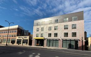 Minneapolis apartment for rent - a brick building with a silver roof on a city street
