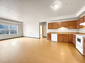 Minneapolis apartment for rent - A kitchen with white appliances and wooden cabinets.