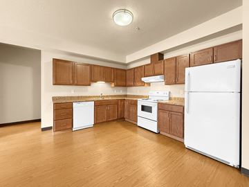Minneapolis apartment for rent - A kitchen with white appliances and wooden cabinets.