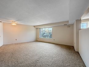 Plymouth townhouse for rent - A sparsely furnished room with a carpeted floor and a window.