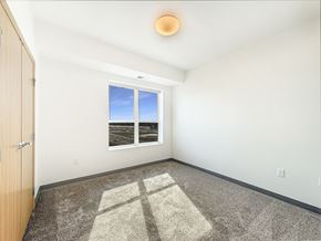 St. Paul apartment for rent - A room at The Lumin in the Highland Park neighborhood of St Paul with a carpeted floor and a window showing a view of a beach.