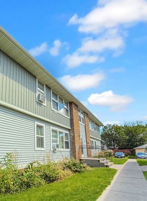 Minneapolis apartment for rent - A residential building with a green siding and a brick chimney.