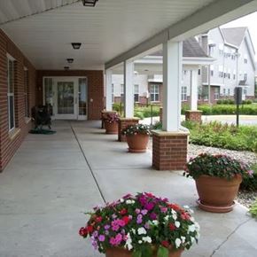 Minnetonka apartment for rent - A porch with a brick wall and a white roof with flower pots on it.