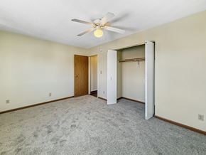 Minneapolis apartment for rent - A room with a ceiling fan and a carpeted floor.