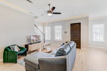 Waxahachie townhouse for rent - A living room with a grey couch and a green armchair.