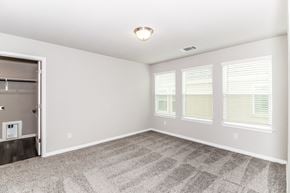 Dripping Springs townhouse for rent - an empty bedroom with three windows and a closet