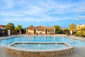 Houston townhouse for rent - A large outdoor swimming pool with a fountain in the middle.