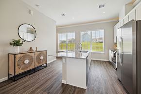 Montgomery townhouse for rent - A kitchen with a white fridge and a round mirror on the wall.