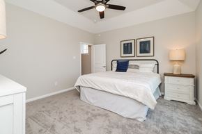Galveston townhouse for rent - a bedroom with a bed and a ceiling fan
