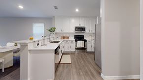 Denton townhouse for rent - A white kitchen with a dining table and chairs.