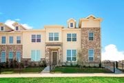 Denton townhouse for rent - A large, two-story house with a black fence in front.