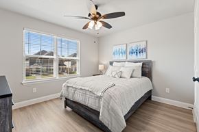 Denton townhouse for rent - A bedroom with a large bed and a ceiling fan.