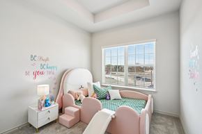 Red Oak townhouse for rent - A child's bedroom with a pink chair and a bed with a green blanket.