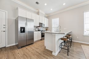 La Marque townhouse for rent - a large kitchen with stainless steel appliances and a bar with stools