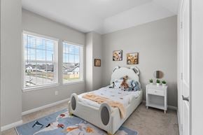 Atascocita townhouse for rent - A bedroom with a large bed and a view of a parking lot through the window.