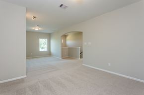Rosharon townhouse for rent - an empty living room and dining room with carpeting and a window