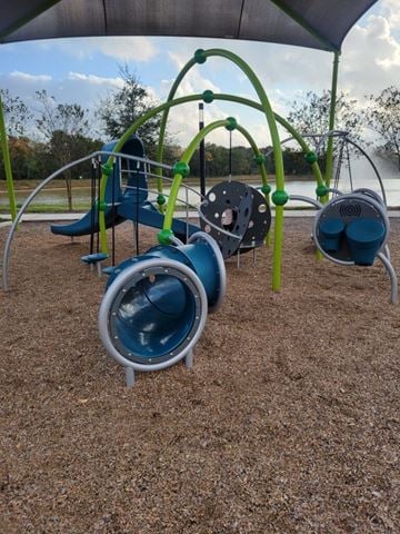 Pearland townhouse for rent - A playground with a blue slide and a green climbing frame.