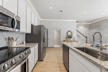 Lewisville townhouse for rent - A kitchen with a stove top oven and a refrigerator.