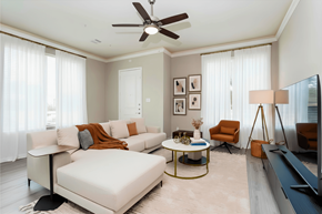 Katy townhouse for rent - A living room with a white sofa, a coffee table, and a ceiling fan.